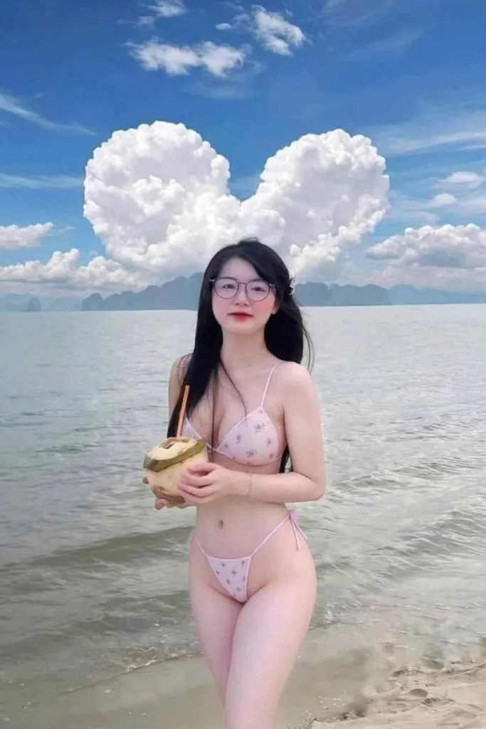 Cô gái xinh đẹp mặc bikini dạo chơi ngoài bãi biển