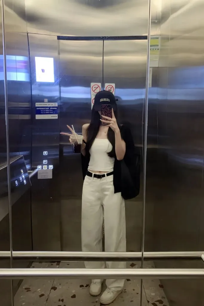 Gái xinh che mặt tạo dáng trong thang máy